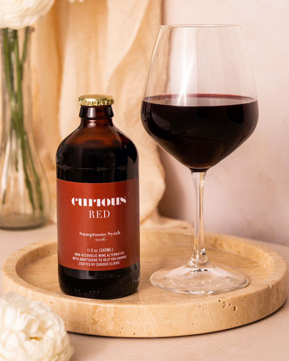 Bottle of Curious Red next to a poured wine glass